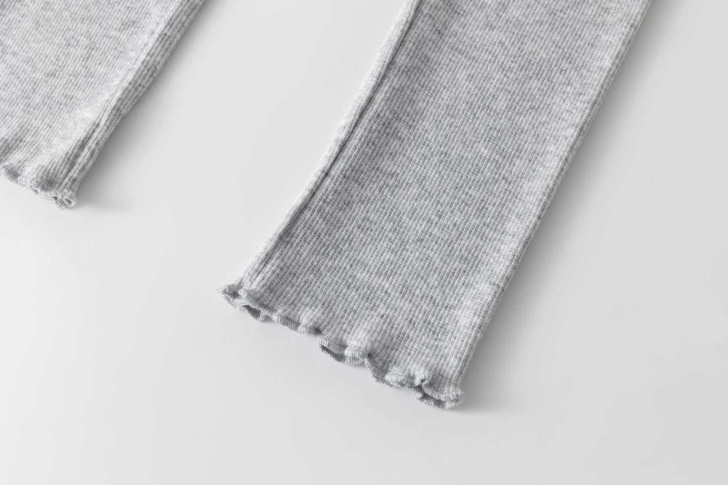 Legging básico de canalé de niña. Cinturilla con goma elástica interior. Volante pequeño en la cintura. Bajo y volante acabado en remallado .