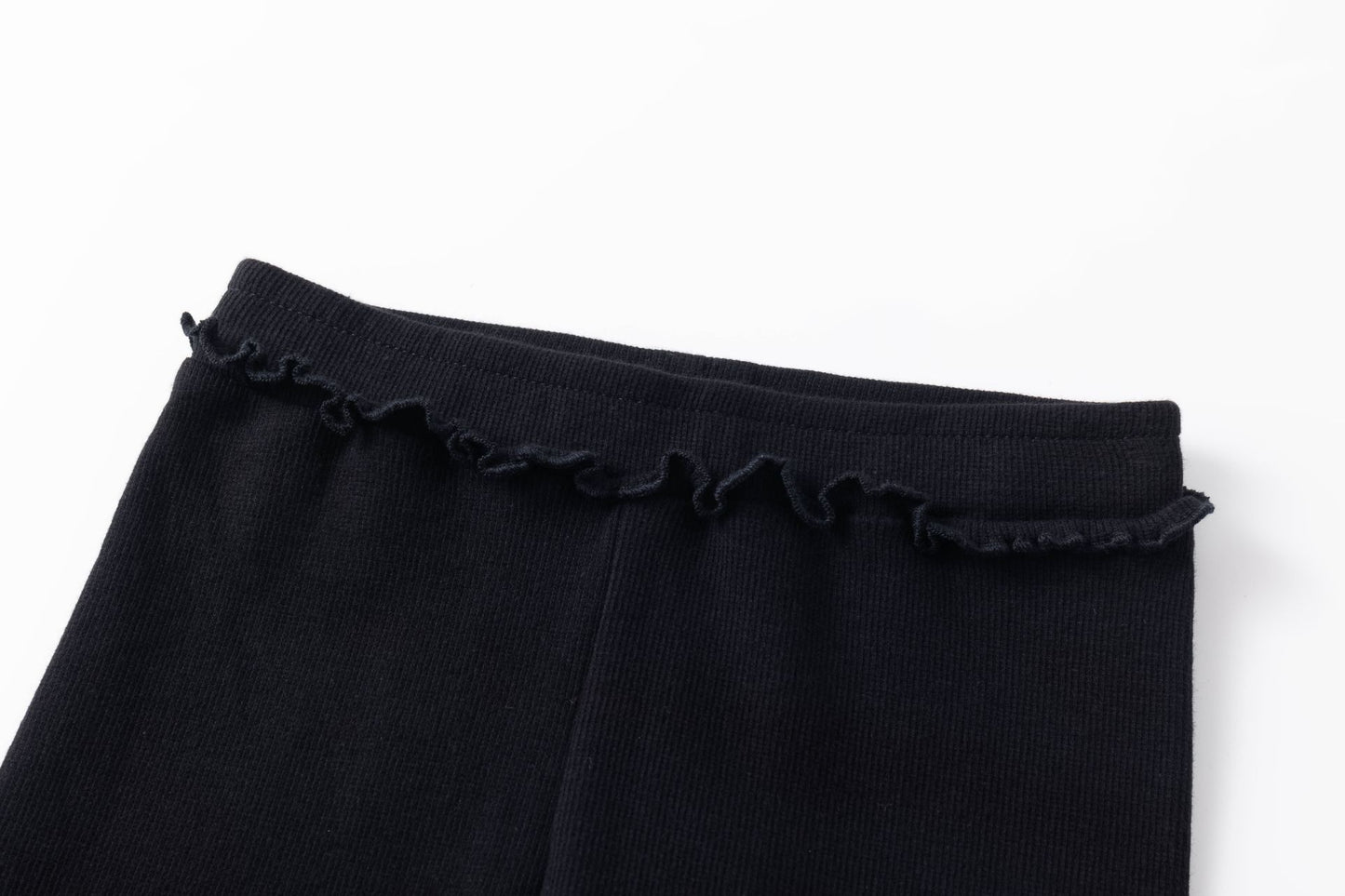 Legging básico de canalé de niña. Cinturilla con goma elástica interior. Volante pequeño en la cintura. Bajo y volante acabado en remallado .