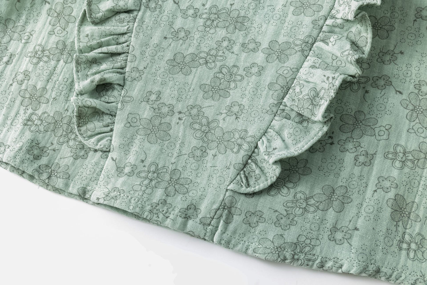 Blusa tejido estampado de flores de niña. Manga larga con goma elástica en el interior de los puños. Dos volantes verticales en el delantero. Abertura con botón de plástico en espalda.