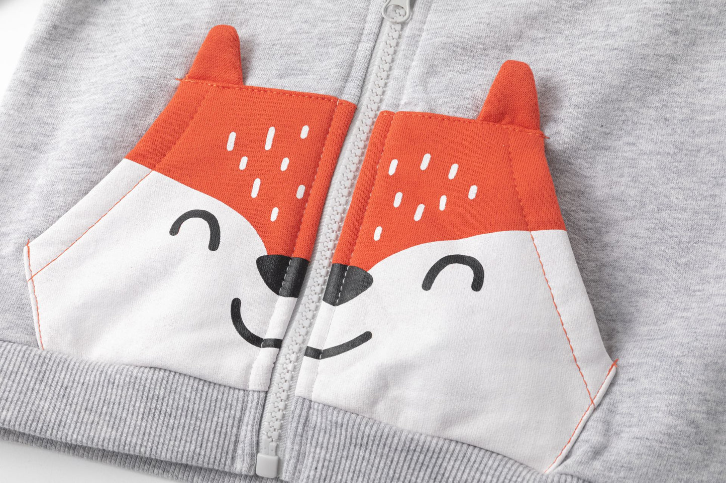 Sudadera de bebe niño abierta con cremallera y capucha. Felpa perchada. Bolsillo canguro frontal con color a contraste, orejas en 3D y con gráfico de de cara de oso. Gráfico de texto en el pecho estampado de relieve.