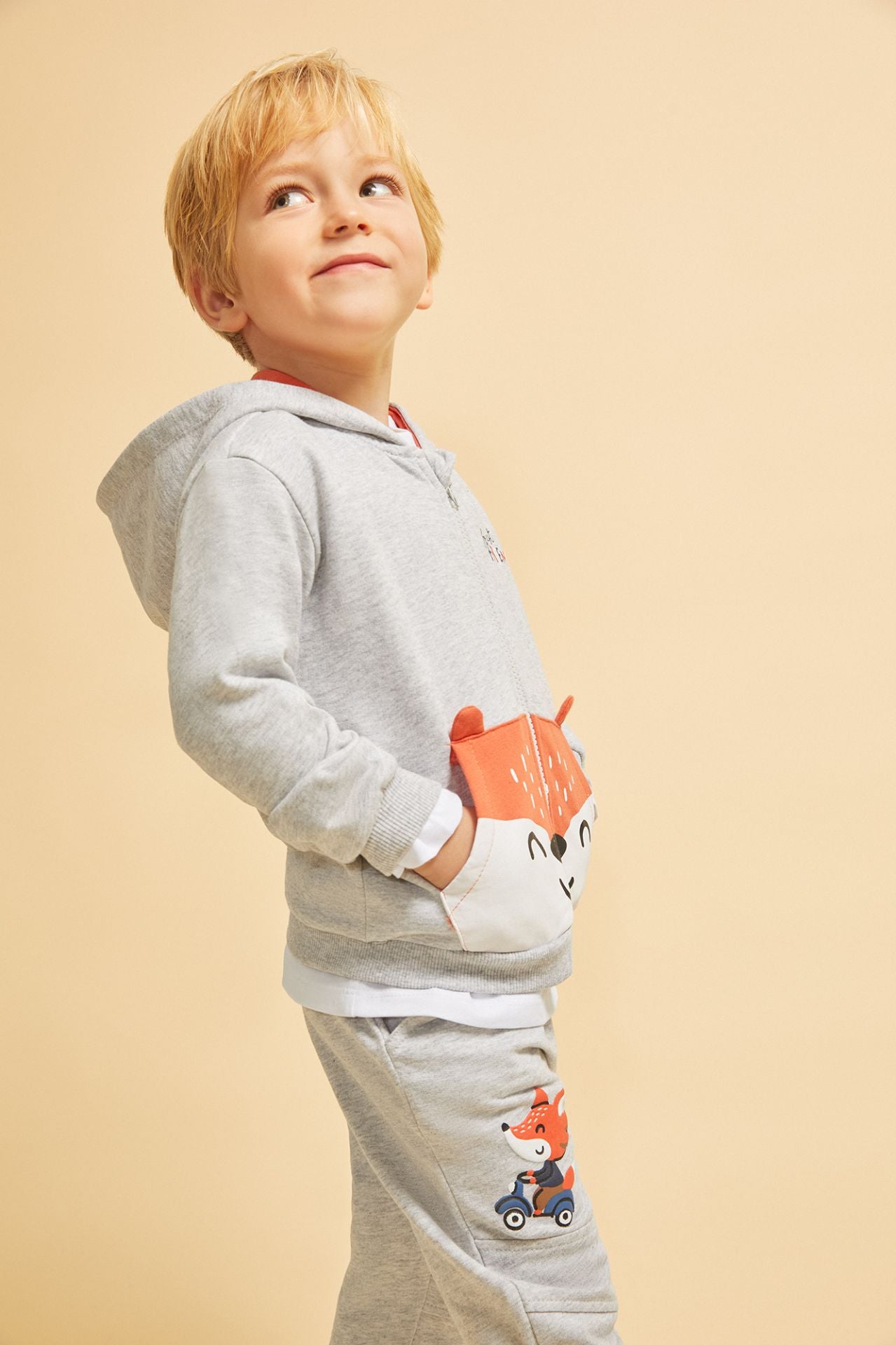 Sudadera de bebe niño abierta con cremallera y capucha. Felpa perchada. Bolsillo canguro frontal con color a contraste, orejas en 3D y con gráfico de de cara de oso. Gráfico de texto en el pecho estampado de relieve.