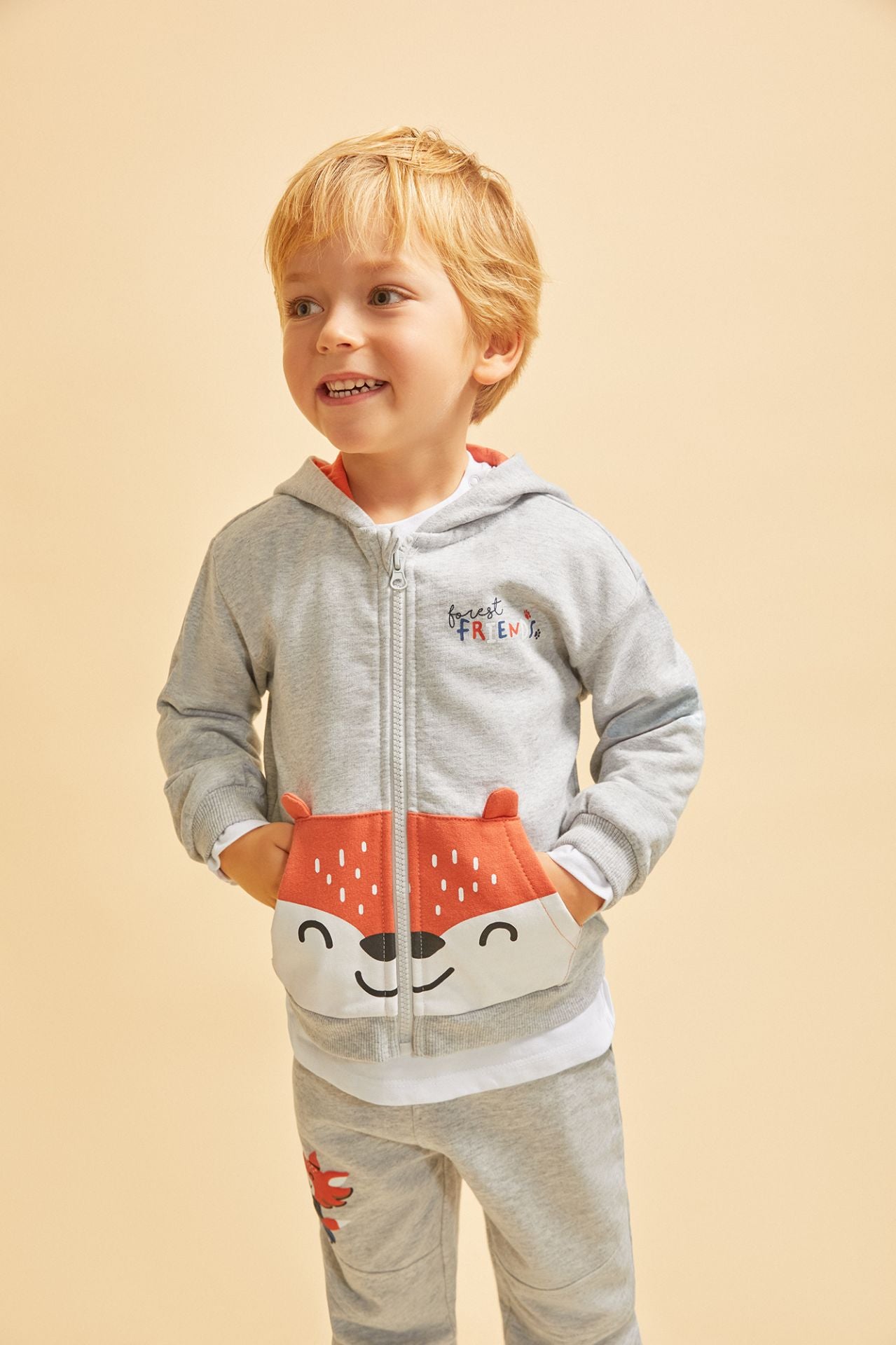 Sudadera de bebe niño abierta con cremallera y capucha. Felpa perchada. Bolsillo canguro frontal con color a contraste, orejas en 3D y con gráfico de de cara de oso. Gráfico de texto en el pecho estampado de relieve.