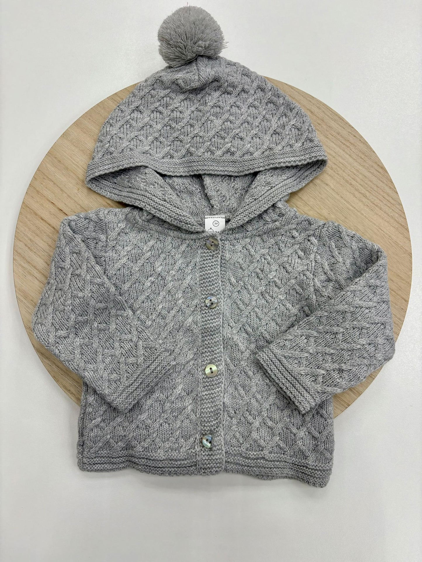 Chaqueta punto bebé con capucha y pompón color gris