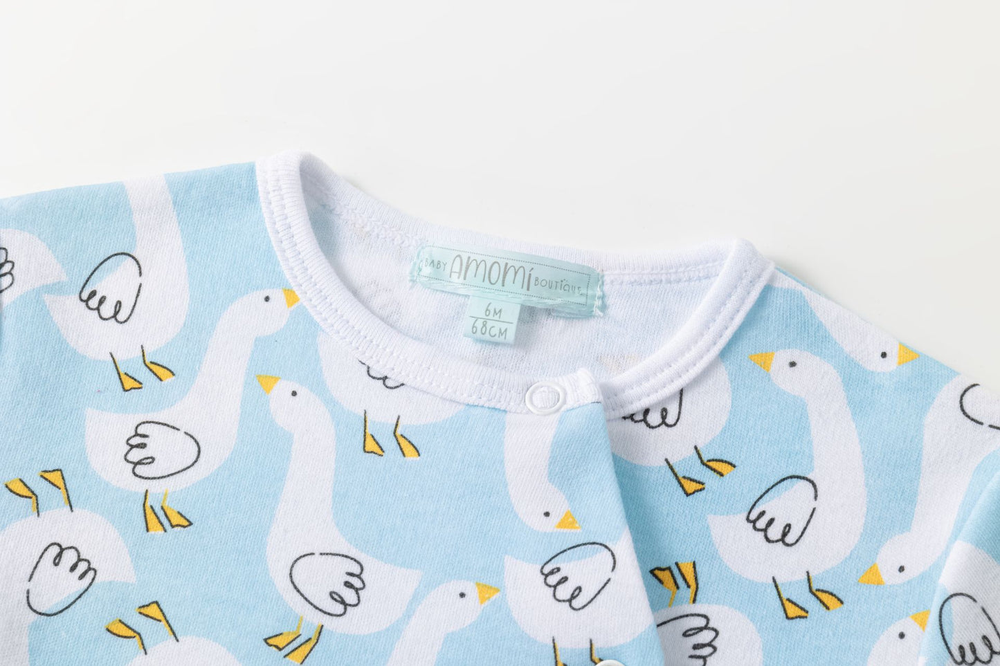 Pijama bebe apertura cruzada delantera con automáticos. Pie cerrado. Estampado de cisnes